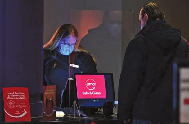 An employee helps a moviegoer with a ticket purchase at AMC Empire 25 off Times Square as New York City’s cinemas reopen for the first time in a year following the coronavirus shutdown, on March 5, 2021 in New York City. (Photo by ANGELA WEISS/AFP via Getty Images/TNS)