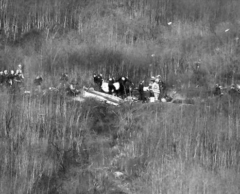 Officials remove a body from the wreckage in Calabasas, Calif., in January 2020 where basketball star Kobe Bryant and eight others died in a helicopter crash. (Christina House/Los Angeles Times/ TNS)