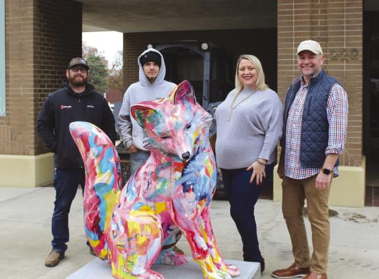 The first of the fox statues was installed downtown on Monday, Dec. 5. This fox is the one belonging to Ponca City Main Street (PCMS) and was painted by artist Kal Cloonan. Pictured to the right of the fox is PCMS Executive Director Maci Graves and City Arts Executive Director Terron Liles. The pair are accompanied by workers with Kyler Construction Group, who installed the statue at its current location outside Equity Bank at 222 E. Grand Avenue. (Photo by Calley Lamar)