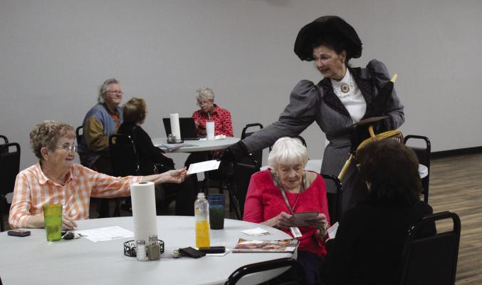 Two reenactors, portraying Mary Virginia Marland and Bill McFadden, visited the Ponca City Senior Center to pass out invitations for g E.W. Marland’s 149th birthday on Saturday, May 6 from 10 am to 3 pm. Pictured is a Mary Virginia Marland handing out invitations. (Photo by Calley Lamar.