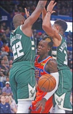 OKLAHOMA CITY Thunder guard Dennis Schroeder, center, loses the ball as he is defended by Milwaukee Bucks forwards Khris Middleton (22) and Giannis Antetokounmpo (34) during an NBA game Sunday in Oklahoma City. Milwaukee won 121-119. (AP Photo)