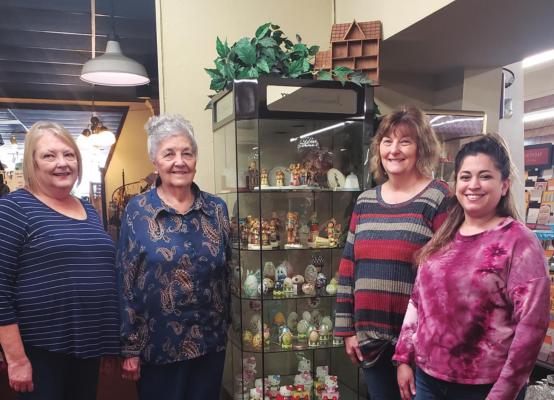From the left, Kathy Pettigrew, Verona Mair, Konni Streeter, and Alyssa Rice standing by the Hummel figurine showcase in the store. Photo by Darlene Engelking