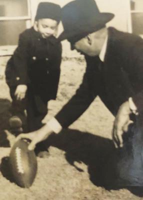 MY DAD bought me my first football. Here he is giving me some pointers on how to kick the fool thing.