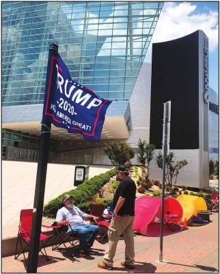 JAMES MASSERY, left, of Preston, Okla., and Daniel Hedman, of Tulsa, Okla., supporters of President Donald Trump, camp outside the BOK Center in Tulsa on Tuesday, June 16, 2020, four days before his scheduled rally Saturday. Trump’s site for a rally on Saturday stands in what’s historically the white downtown, a few hundred feet from a once-thriving black community wiped out by a white massacre in 1921. (AP Photo)