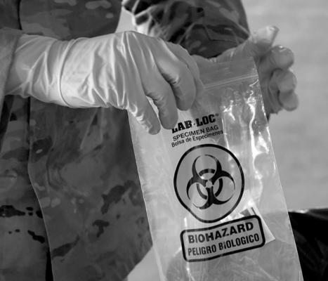 Spc. Jonathan Macias of the Nevada National Guard put a coronavirus (COVID-19) specimen sampling tube into a bag after administering a test during a preview of a free drive-thru COVID-19 testing site in the parking garage of the Texas Station Gambling Hall &amp; Hotel on November 12, 2020 in North Las Vegas, Nevada. (Ethan Miller/Getty Images/TNS)