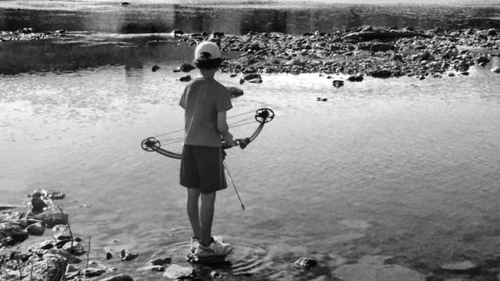 A YOUNG bow fisherman scans the water on the Red River. (Photo provided by Phil Reno)