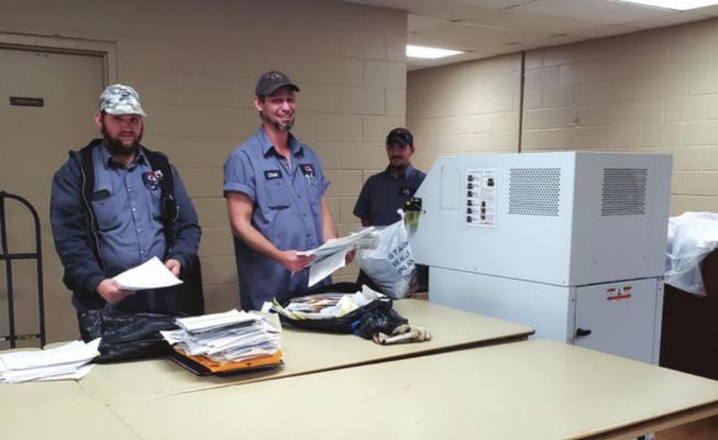Assisting with the shredding of personal papers on site from the left: Dale McSmith, Chad Harless and Tyson DeBree.