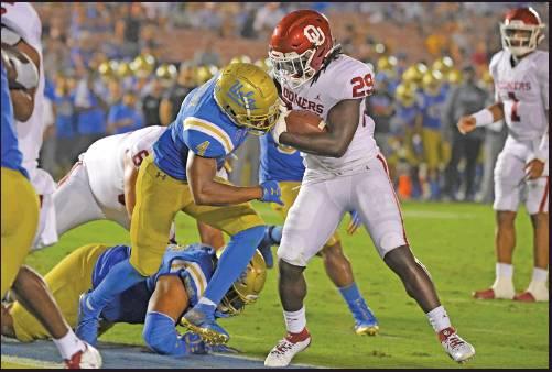 OKLAHOMA RUNNING back Rhamondre Stevenson, right, scores a touchdown as UCLA defensive back Stephan Blaylock defends during the second half of an NCAA college football game Sept. 14 in Pasadena, Calif. The Sooners running game ranks No. 2 in the nation going into Saturday’s game. (AP Photo)
