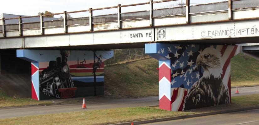 WHEN CHOOSING themes for the railroad underpass, the Sackets chose to include something representative of the railroad and Ponca City. The first mural (on the left) depicts a locomotive, a lineworker, and an oil derrick; while the second mural (on the right) is a patriotic bald eagle, Theresa Sacket chose this as a means of honoring veterans. (Photo by Dailyn Emery)