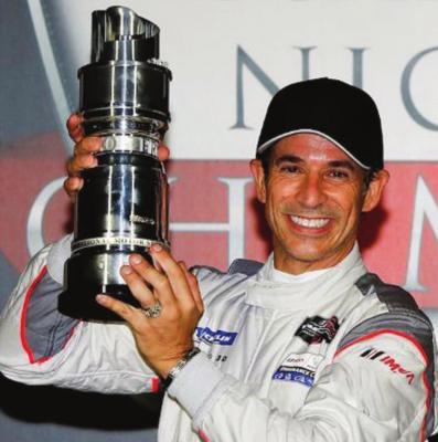 HELIO CASTRONEVES of Brazil holds up trophy after winning Indianapolis 500 race. He won for the fourth time in the big race over the weekend.