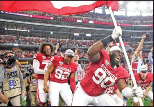 OKLAHOMA DEFENSIVE lineman Neville Gallimore (90) plants a University of Oklahoma flag after the Sooners 30-23 overtime win over Baylor in a game for the Big 12 Conference championship Dec. 7, in Arlington, Texas. The Sooner defense is gearing up for Saturday’ College Football Playoff semifinal game with LSU. (AP Photo)