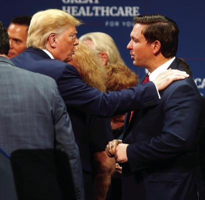 In this 2019 image, then-President Donald Trump talks to Florida Gov. Ron DeSantis after giving a speech to his supporters at the Sharon L. Morse Performing Arts Center in The Villages, Fla. (Octavio Jones/Tampa Bay Times/TNS)