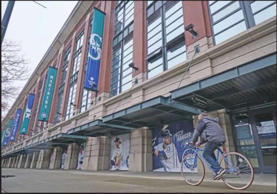 A BICYCLE rider rides past T-Mobile Park March 11 in Seattle, where baseball’s Seattle Mariners plays home games. In efforts to slow the spread of the COVID-19 coronavirus, Washington State Gov. Jay Inslee announced a ban on large public gatherings in three counties in the metro Seattle area. That decision impacts the Seattle Mariners, Seattle Sounders, and the XFL’s Seattle Dragons home games. (AP Photo)