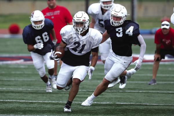 BALL CARRIER Alonzo Biggoose (21) is being chased by Hudson Haas (34) and Caesar Jimenez (66) during Saturday’s Red/Navy Scrimmage at Sullins Stadium. Coach Scott Harmon was pleased overall by the action on the field. This photo was provided by Larry Williams.