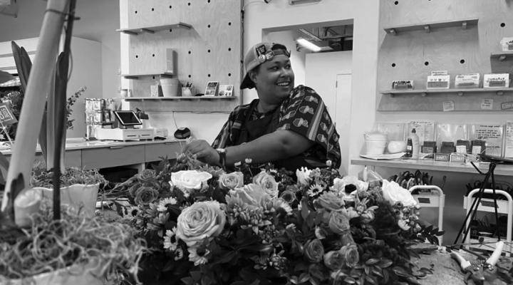D’Metryus Freeman adds flowers to a wreath while at work at Curbside Flowers on Jan. 12. Curbside Flowers employees were preparing the arrangement for a Homeless Alliance funeral honoring 67 people that had died in 2022 while experiencing homelessness or after having been housed. (Ari Fife/Oklahoma Watch)
