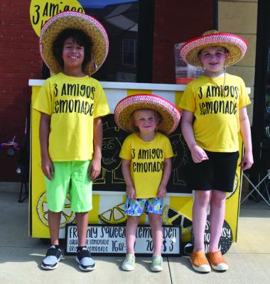 THE THREE Amigos were one of many lemonade stands seen along Grand Avenue Saturday morning for the annual Crazy Days celebration in Downtown Ponca City, as many businesses opened their doors and welcomed the public for great sales and discounts in the summer. Shown from left are the Three Amigos Julan Zeledon and Brydger and Jagger Johnson. (Photo Everett Brazil, III)