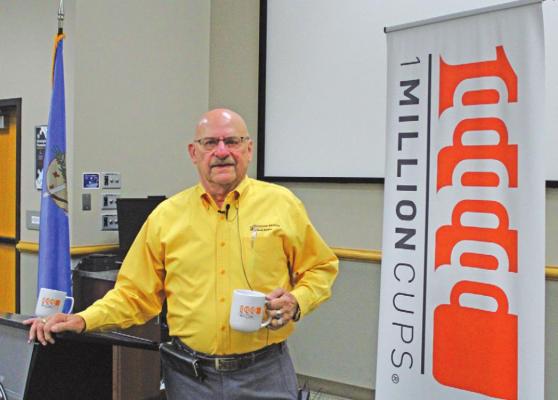 Mayor Homer Nicholson at the One Million Cups meeting with an orange cup the organization presents to speakers. (Photo by Calley Lamar)