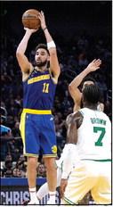 The Golden State Warriors’ Klay Thompson (11) shoots and scores over the Boston Celtics’ Jaylen Brown (7) and Jayson Tatum (0) during the second quarter at Chase Center on Saturday, Dec. 10, 2022, in San Francisco. (Thearon W. Henderson/Getty Images/ TNS)