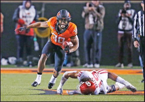 OKLAHOMA STATE running back Chuba Hubbard (30) avoids a tackle by Oklahoma linebacker Caleb Kelly (19) in the a football game in Stillwater Nov. 30. The Cowboys were invited to the Texas Bowl where they will play Texas A&amp;M Dec. 27. (AP Photo)