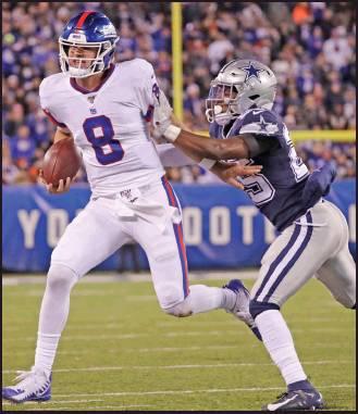 NEW YORK Giants quarterback Daniel Jones (8) is forced out of bounds by Dallas Cowboys free safety Xavier Woods (25) during an NFL game Monday in East Rutherford, N.J. The Cowboys won 37-18. (AP Photo)