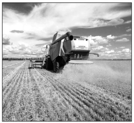 Farmers harvest a wheat field in the Ukrainian Kharkiv region on July 19, 2022, amid Russian invasion of Ukraine. (Sergey Bobok/ AFP via Getty Images/TNS)