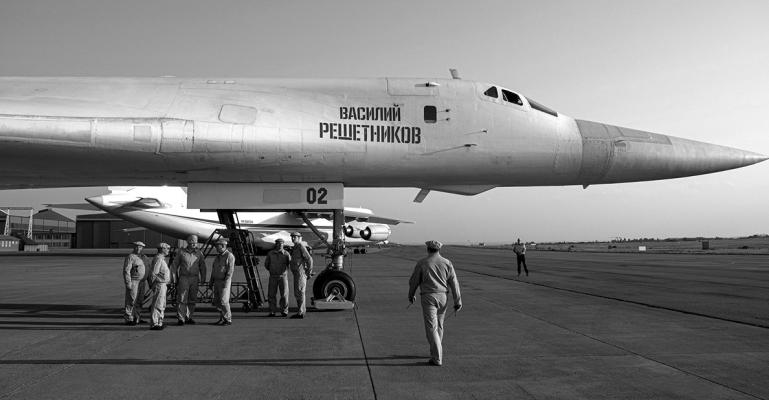 MILITARY PERSONNEL gather under a Russian Air Force Tupolev Tu-160 “Blackjack,” a supersonic variable-sweep wing heavy strategic bomber, is parked on the tarmac at the Waterkloof Air force Base in Centurion, south of Pretoria, northeastern South Africa, on Oct. 23, 2019. (Emmanuel Croset/ AFP via Getty Images/TNS)