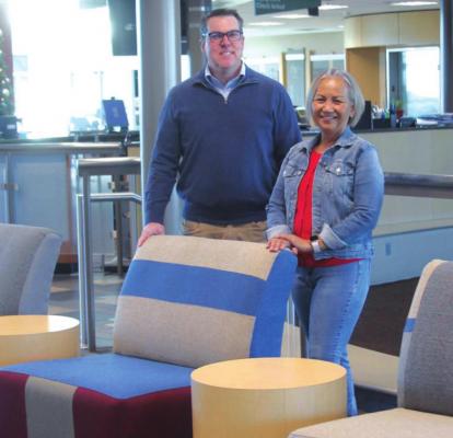 In the Ponca City Rec Plex, Ryan Hafen and Yasmin Williams standing by the lobby chairs Williams upholstered. Photo by Darlene Fields
