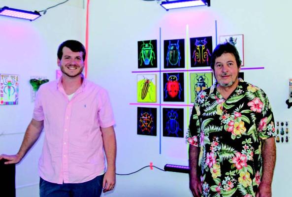 The Doodle Academy hosted its August Art Exhibition on Fri., Aug. 26th. Artists Dale Coons and Joshua Cook, the featured artists, show off their interactive blacklight section of the exhibit. (Photo by Dailyn Emery)